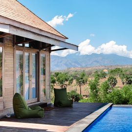 Lodge veranda by pool overlooking green scenary in the background
