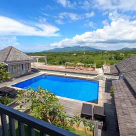 View of pool from balcony with mountain in the distance