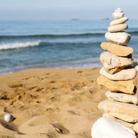 Volunteers stack stones on beach in Argostoli in Greece