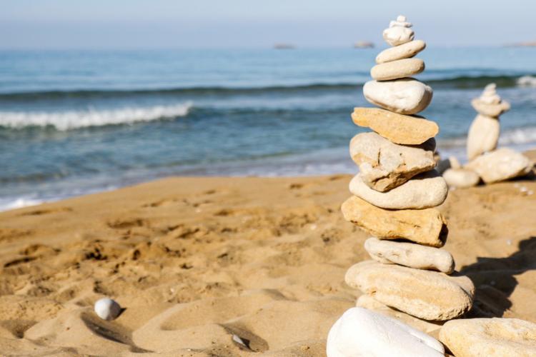 Volunteers stack stones on beach in Argostoli in Greece