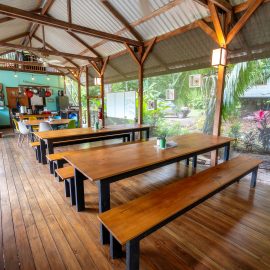 Long open platform for kitchen with two big tables and benches