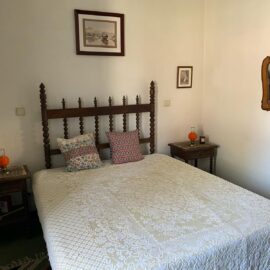 Double bed in middle of room with picture frames on the walls