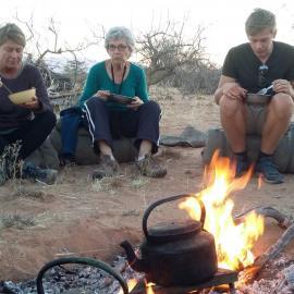 Volunteers eating dinner around a fire in Namibia