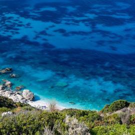 Volunteers watch turquoise waters at Lixouri in Greece