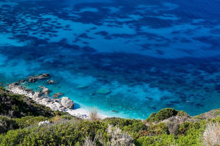Volunteers watch turquoise waters at Lixouri in Greece