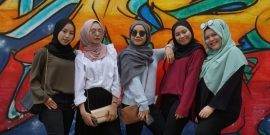 Group of women in front of a mural