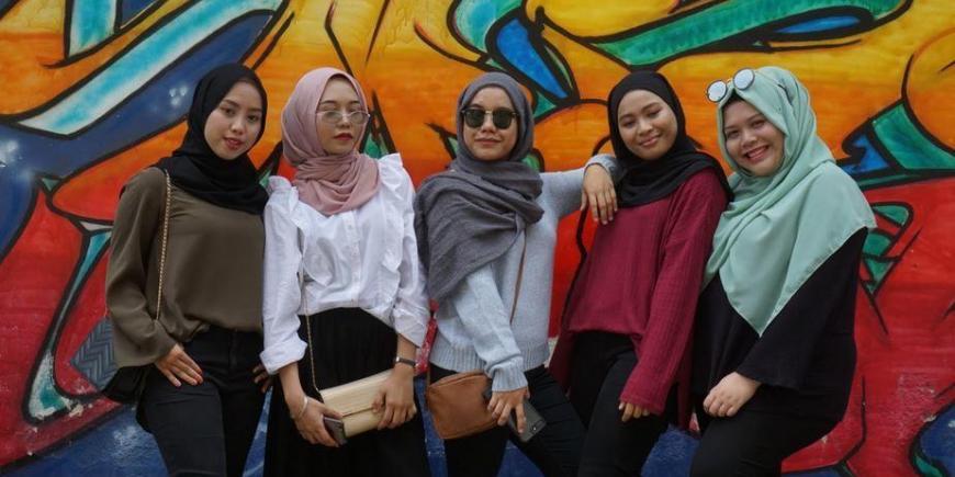 Group of women in front of a mural