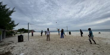Volunteers playing volleyball on the beach