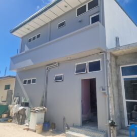 White volunteer house with several floors and small windows.