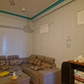 Volunteer house living room with sofas, table and book shelf