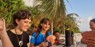 Volunteers playing cards around wooden table