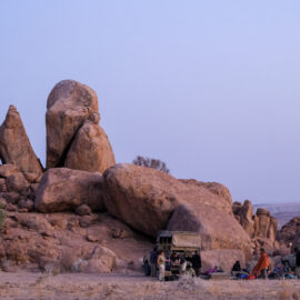Volunteer camp beneath the large cliff rock formation