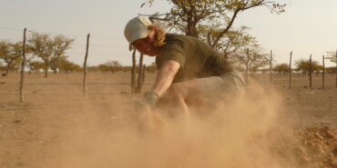 Volunteer smiling while shovelling sand