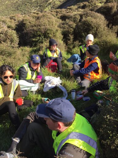 Volunteer group sitting on the ground having their break