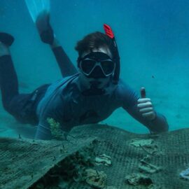 Volunteer under water with snorkelling kit on