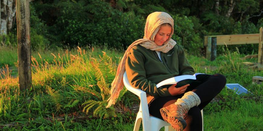 Volunteer reading at nature reserve in New Zealand