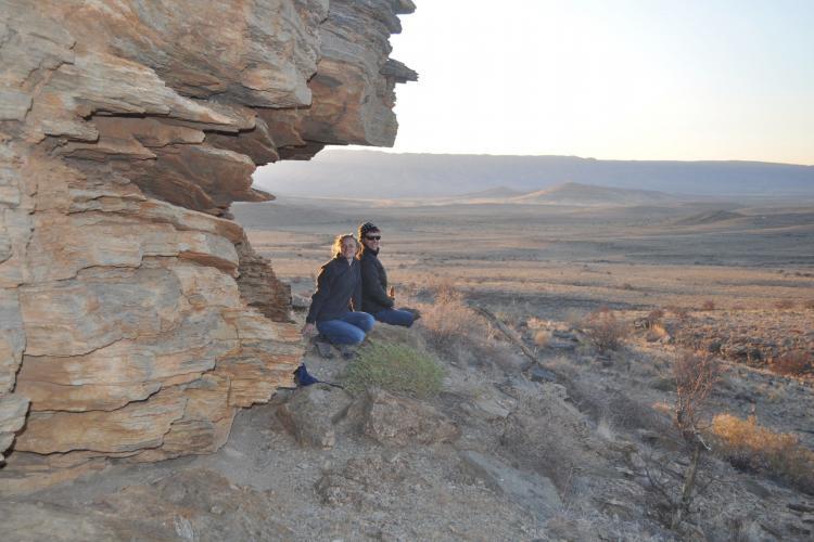 Volunteers sitting on the cliff top overlooking the canyon in the Namib-Naukluft National Park in Namibia