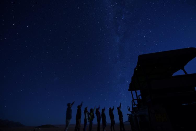 Volunteers under the night sky in Kanaan Desert in Namibia