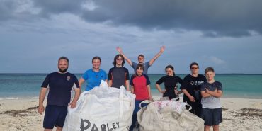 Family volunteering doing beach cleanups in the Maldives