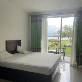 Big bed inside room with large windows with view outside