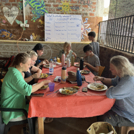 People sitting around a long table eating dinner together
